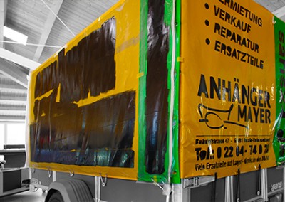 Beschriftung eines Planenanhängers mit Schablone und Siebdruckfarbe